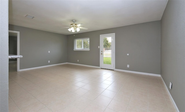 spare room with ceiling fan and light tile patterned flooring