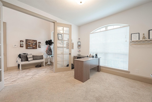 carpeted office space featuring french doors and lofted ceiling