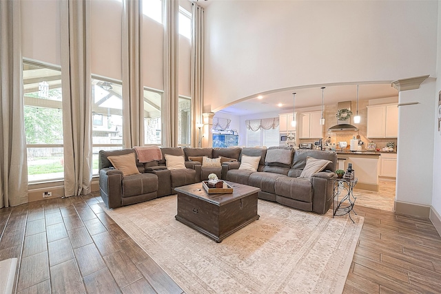 living room featuring decorative columns and a high ceiling