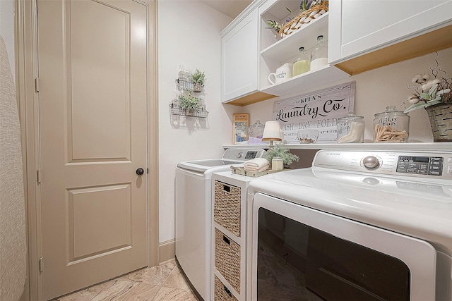 clothes washing area featuring washing machine and dryer and cabinets