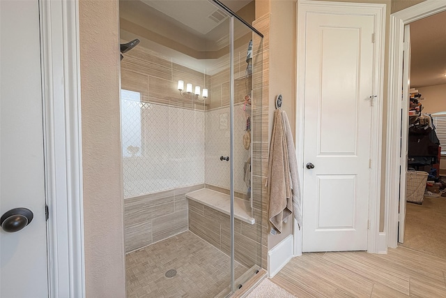 bathroom featuring a shower with door