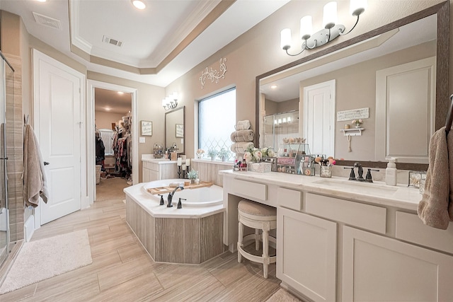 bathroom with vanity, a tray ceiling, ornamental molding, and plus walk in shower