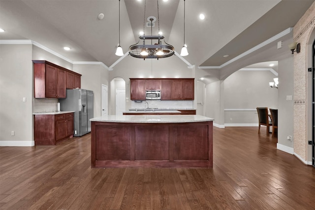 kitchen featuring tasteful backsplash, appliances with stainless steel finishes, crown molding, and hanging light fixtures