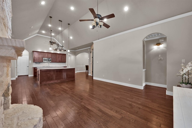 kitchen with decorative light fixtures, high vaulted ceiling, a center island, and ceiling fan