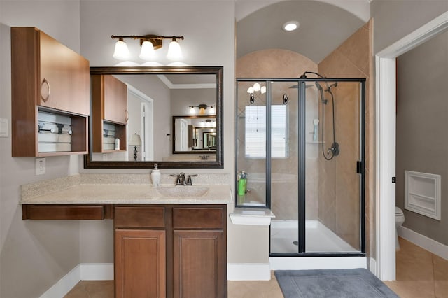 bathroom featuring tile patterned flooring, vanity, an enclosed shower, and toilet