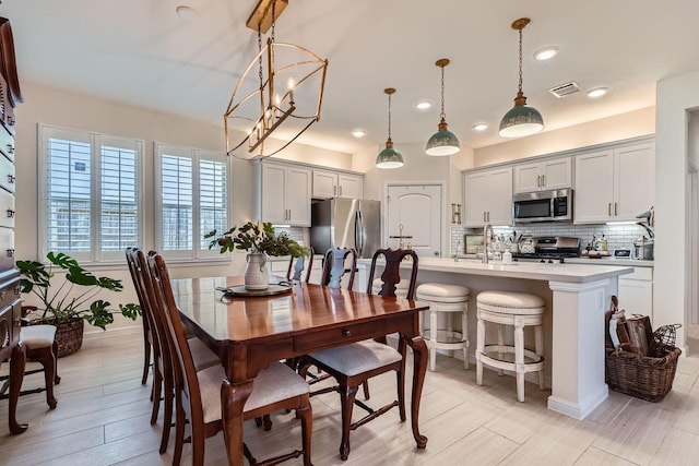 dining area featuring light wood-type flooring, visible vents, baseboards, and recessed lighting