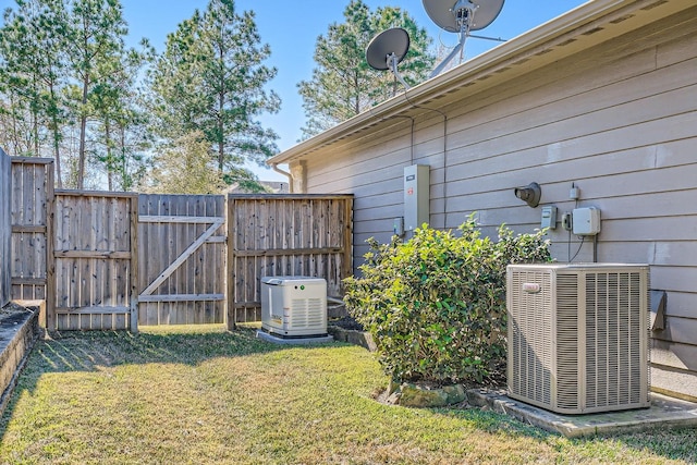 view of yard featuring cooling unit, a gate, and fence