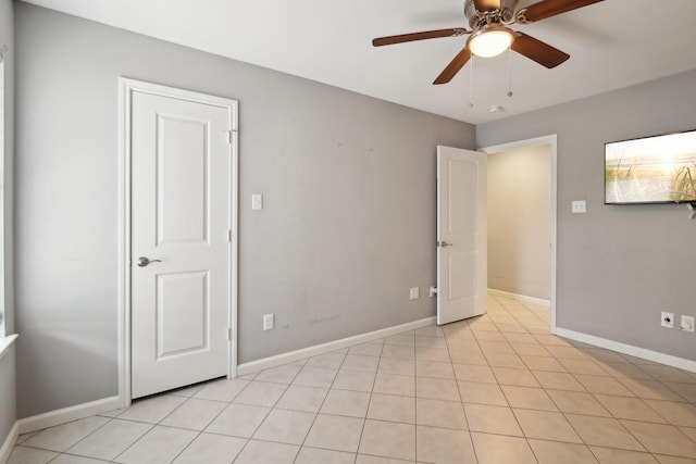 tiled spare room featuring ceiling fan