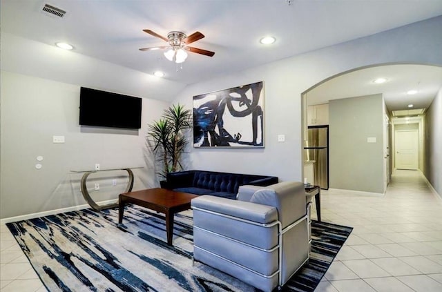 living room with lofted ceiling, light tile patterned floors, and ceiling fan