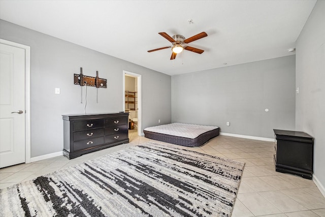 bedroom featuring connected bathroom, light tile patterned floors, and ceiling fan