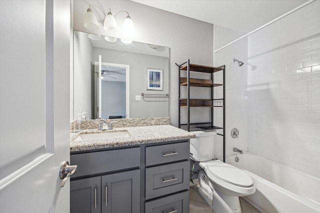 full bathroom with vanity, ceiling fan, tiled shower / bath combo, and toilet