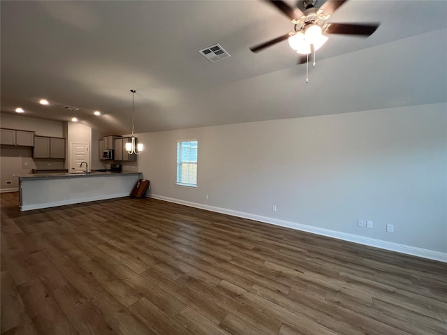 unfurnished living room featuring lofted ceiling, dark hardwood / wood-style floors, and ceiling fan