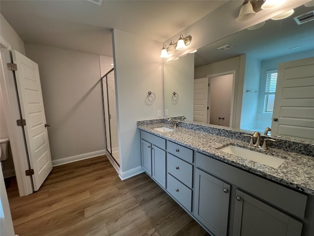 bathroom featuring vanity, hardwood / wood-style floors, and a shower with door