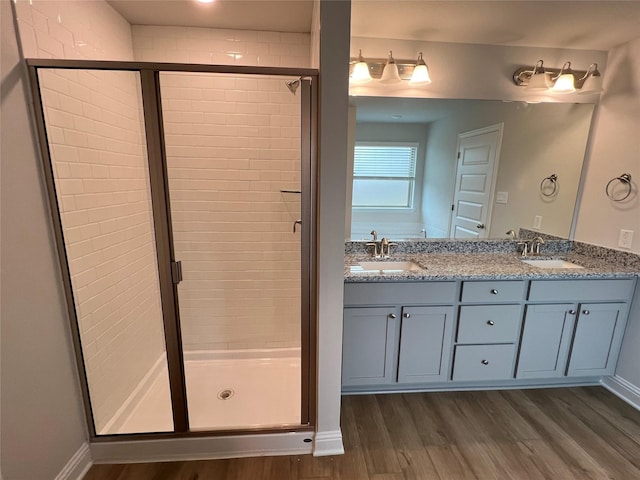 bathroom featuring vanity, hardwood / wood-style floors, and a shower with door