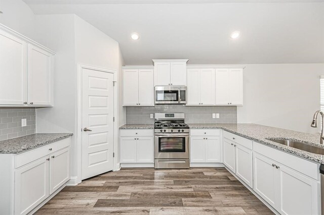 kitchen featuring appliances with stainless steel finishes, a sink, and white cabinets