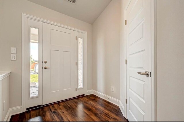 foyer featuring dark wood-type flooring and baseboards