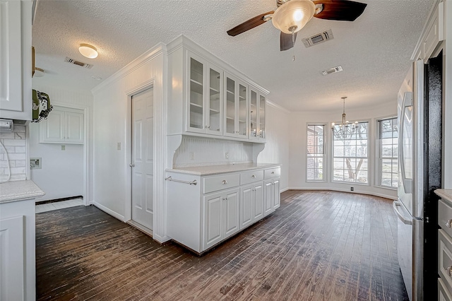 kitchen featuring crown molding, white cabinets, and stainless steel refrigerator