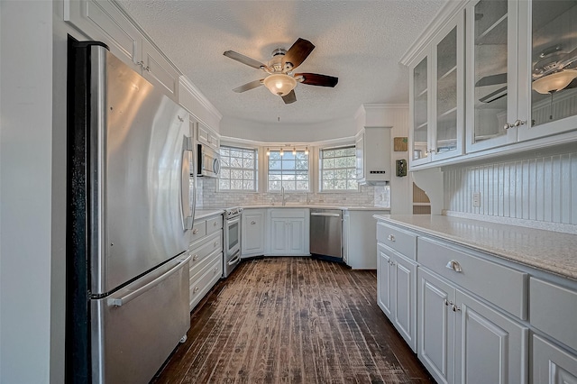 kitchen with dark hardwood / wood-style floors, tasteful backsplash, sink, white cabinets, and stainless steel appliances