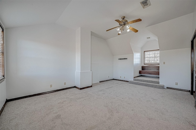 additional living space with ceiling fan, vaulted ceiling, and light carpet