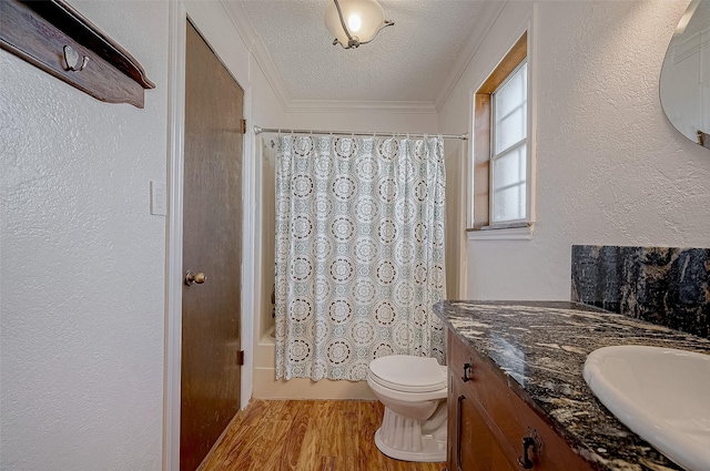 full bathroom with wood-type flooring, ornamental molding, vanity, shower / bathtub combination with curtain, and a textured ceiling