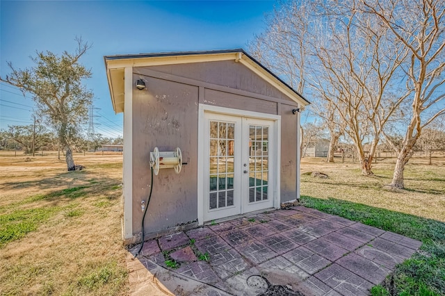 view of outbuilding with a yard and french doors