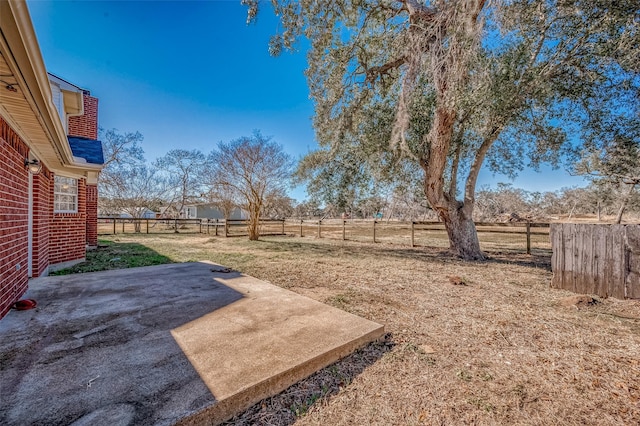 view of yard with a rural view and a patio area