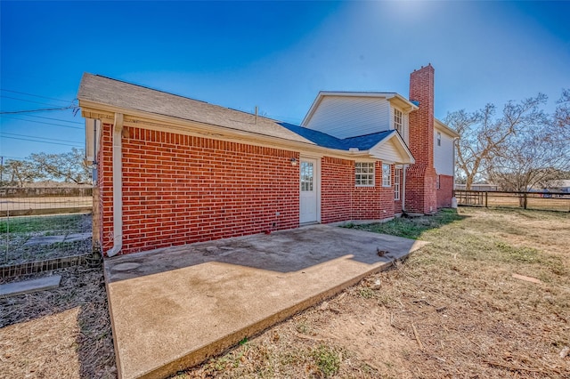 back of property with a yard and a patio area