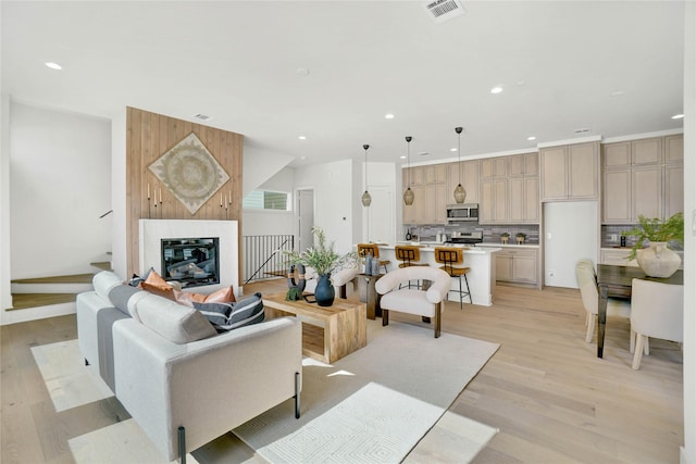 living room with a premium fireplace and light wood-type flooring