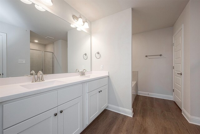 bathroom featuring hardwood / wood-style flooring, shower with separate bathtub, and vanity