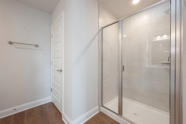 bathroom with hardwood / wood-style flooring and a shower with door