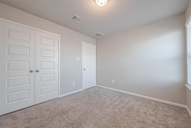 unfurnished bedroom with a closet and carpet flooring