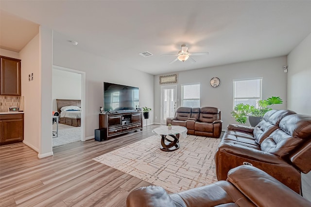 living room featuring light hardwood / wood-style floors and ceiling fan