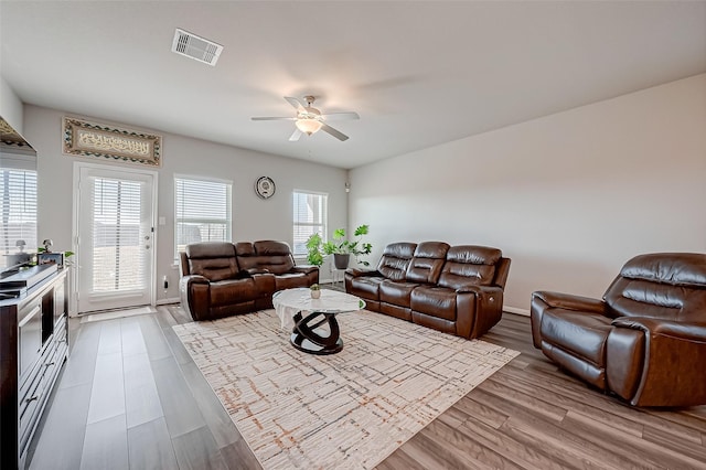 living room featuring ceiling fan and light hardwood / wood-style floors