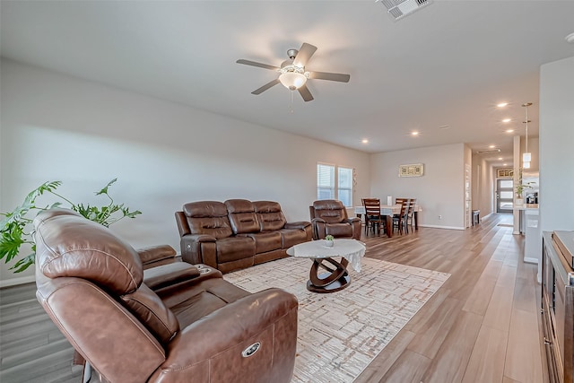 living room featuring ceiling fan and light wood-type flooring