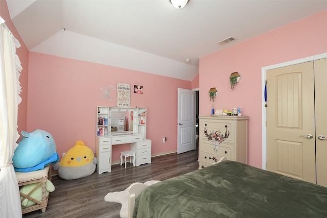 bedroom with vaulted ceiling, dark wood-type flooring, and a closet