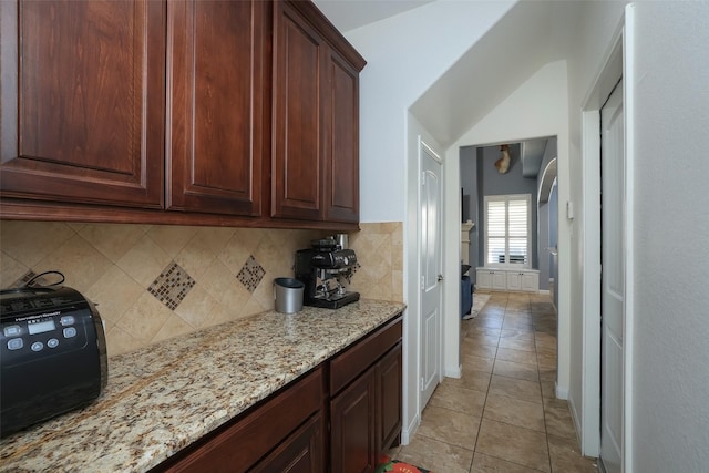 kitchen featuring tasteful backsplash, light stone countertops, and light tile patterned flooring