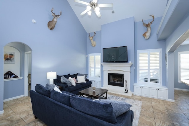 tiled living room featuring ceiling fan and high vaulted ceiling