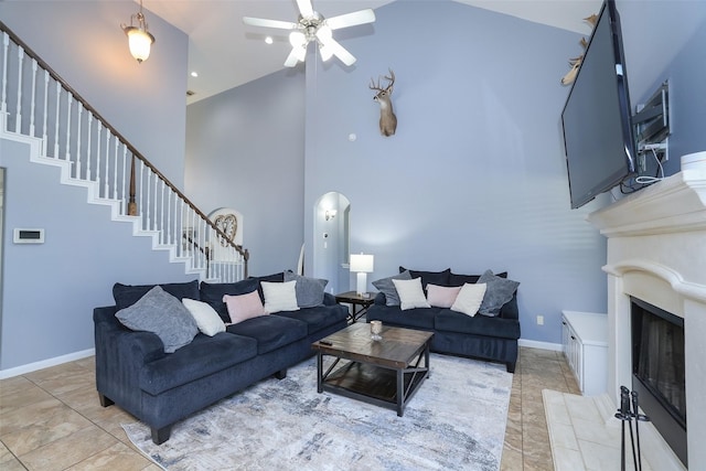 tiled living room featuring ceiling fan and a high ceiling