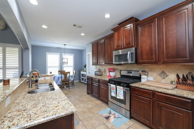 kitchen featuring pendant lighting, sink, light tile patterned floors, appliances with stainless steel finishes, and backsplash