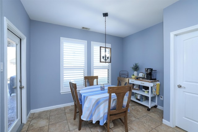 dining space featuring light tile patterned floors, a chandelier, and a healthy amount of sunlight