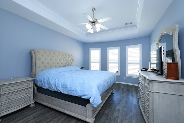 bedroom with dark hardwood / wood-style flooring, a tray ceiling, and ceiling fan