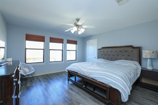 bedroom with ceiling fan, dark hardwood / wood-style floors, and multiple windows