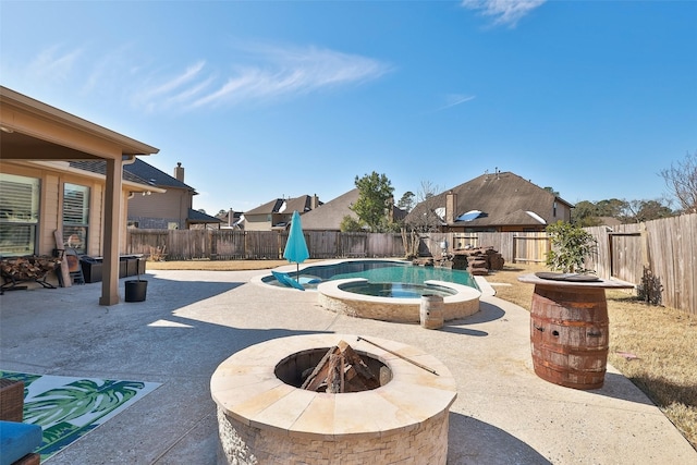 view of swimming pool with an in ground hot tub, a patio, and an outdoor fire pit