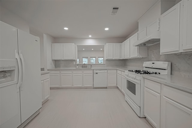 kitchen featuring tasteful backsplash, white cabinetry, sink, and white appliances