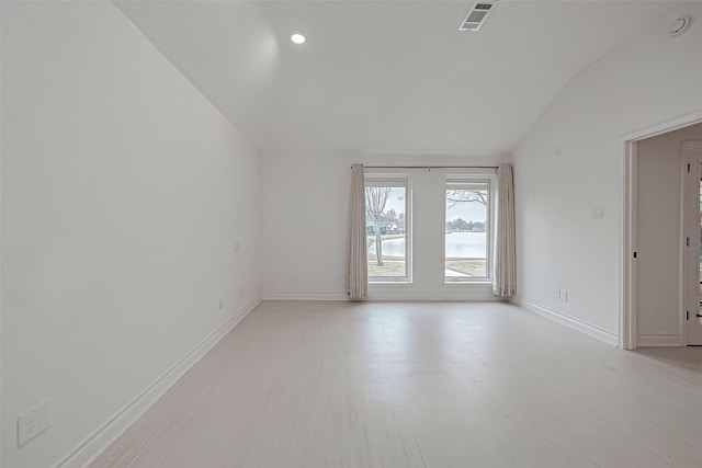 empty room featuring lofted ceiling and light hardwood / wood-style flooring