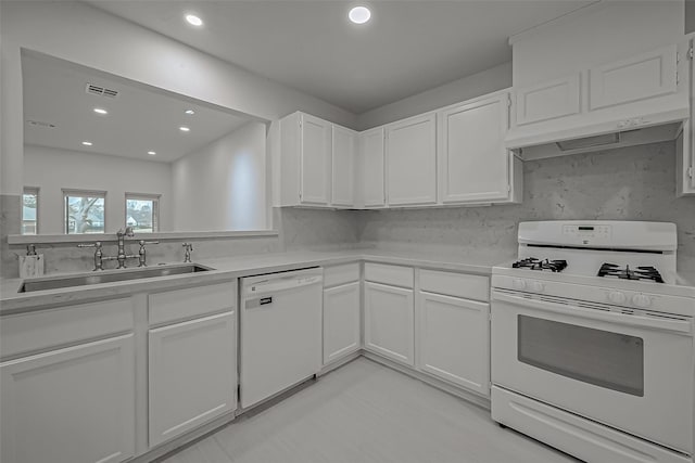 kitchen with white cabinetry, sink, and white appliances