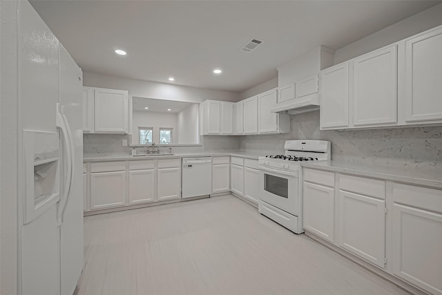 kitchen with white cabinetry, sink, backsplash, and white appliances