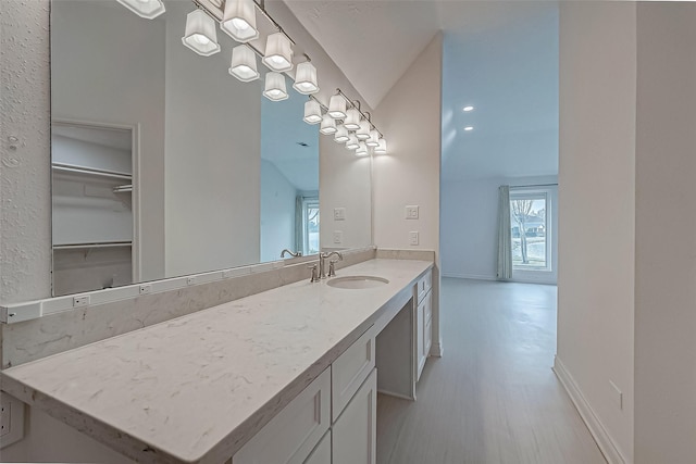 bathroom with vanity and vaulted ceiling