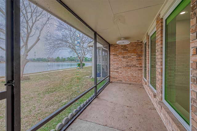 unfurnished sunroom featuring a water view