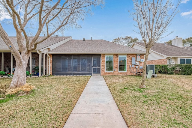 ranch-style house with a sunroom, a front yard, and cooling unit